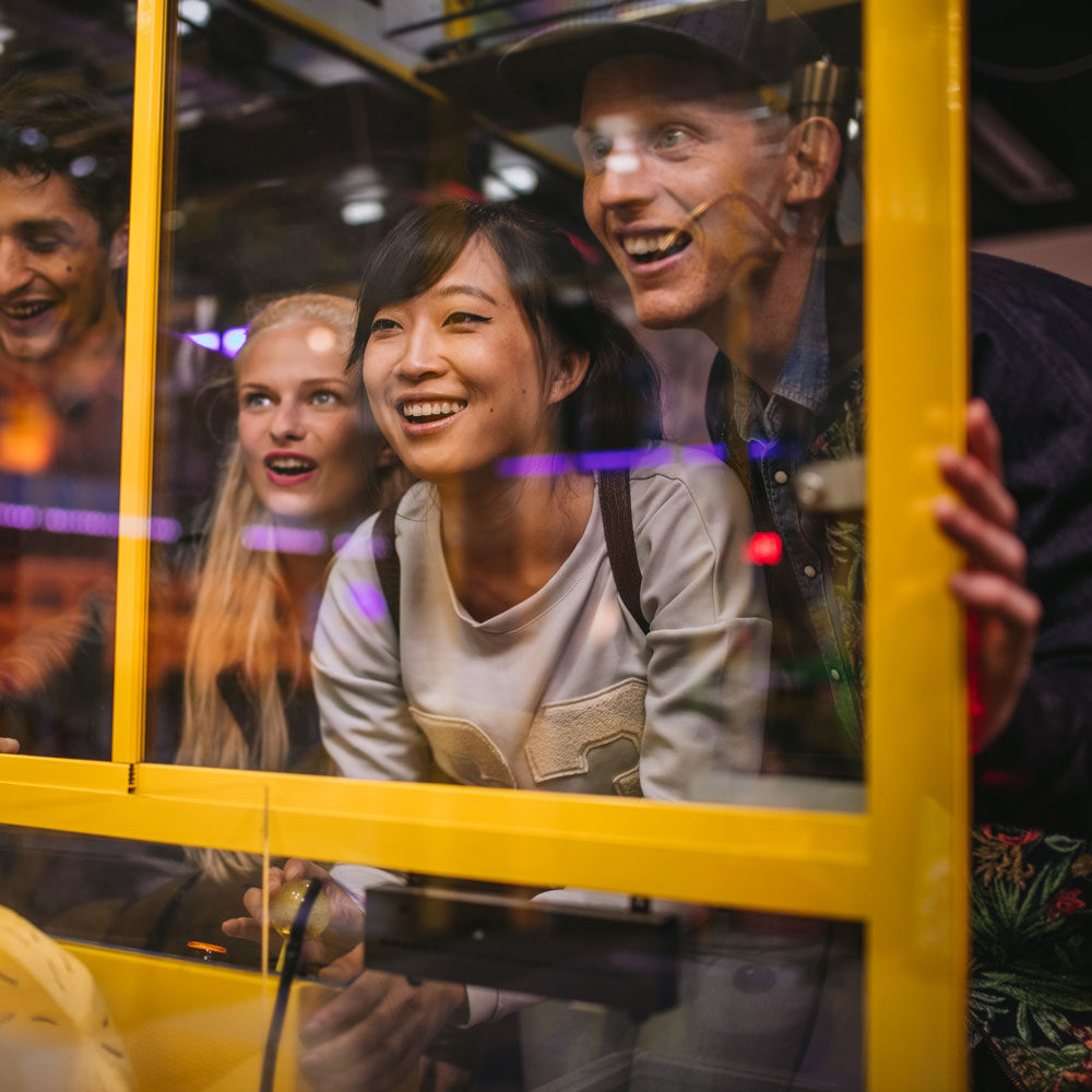 people enjoying a claw machine